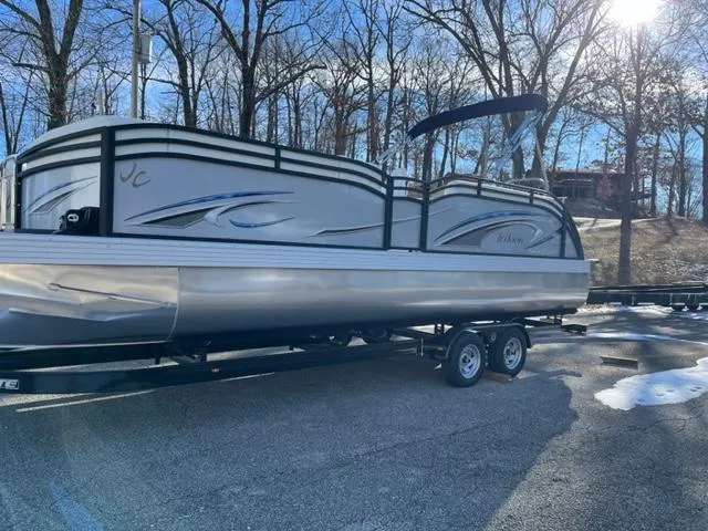 Slide: The Image of 2023 JC 25 Neptoon pontoon boat on trailer, parked outdoors. - 0
