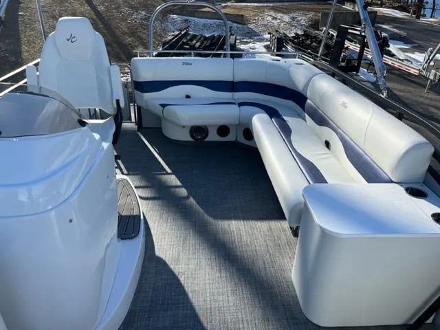 Slide: The Image of 2023 JC 25 Neptoon pontoon boat interior with white and blue seating. - 2