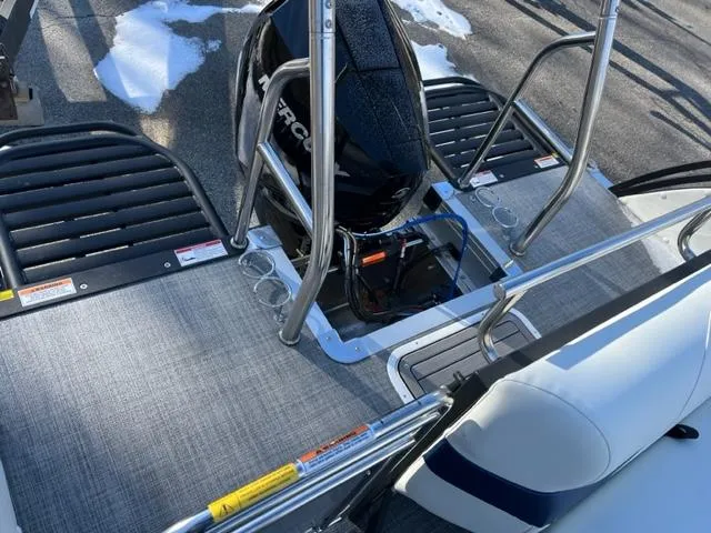 Slide: The Image of 2023 JC 25 Neptoon boat deck with motor, stainless steel rails, and textured flooring. - 5