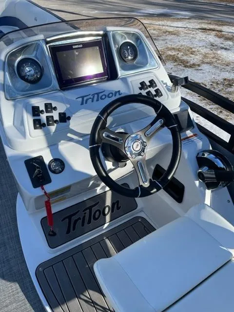 Slide: The Image of 2023 JC 25 Neptoon boat dashboard with steering wheel and controls. - 9