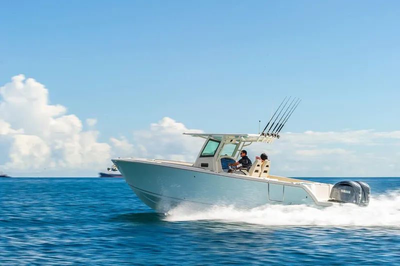 Slide: The Image of 2024 Sailfish 312 CC boat cruising on open water under clear skies. - 0
