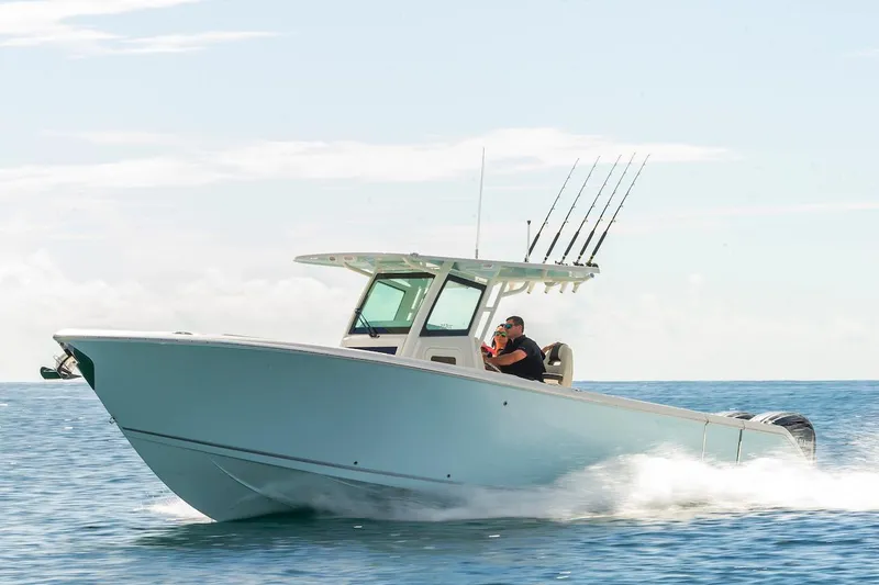 Slide: The Image of 2024 Sailfish 312 CC boat cruising on open water under clear skies. - 1