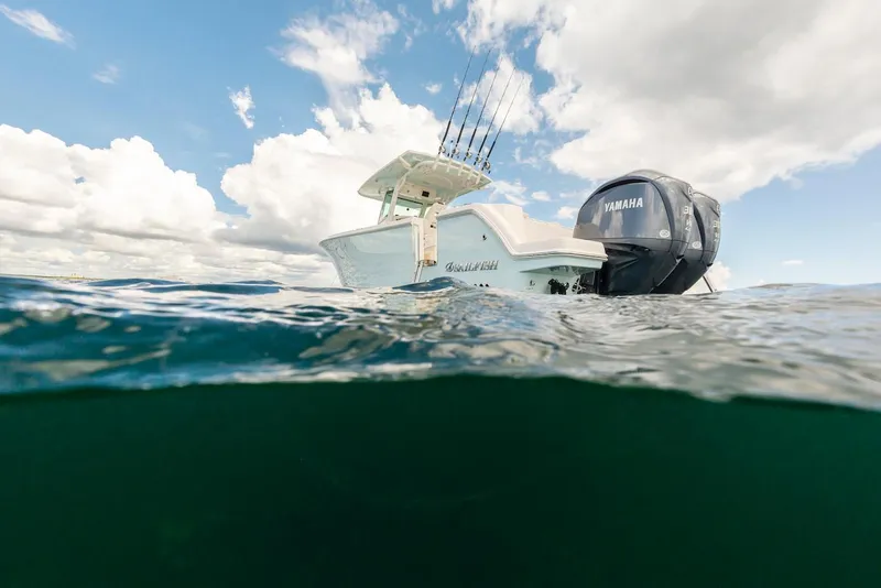 Slide: The Image of 2024 Sailfish 312 CC boat on water, Yamaha engine, under cloudy sky. - 12