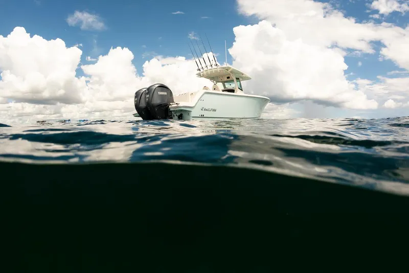 Slide: The Image of 2024 Sailfish 312 CC boat on water under cloudy sky. - 14