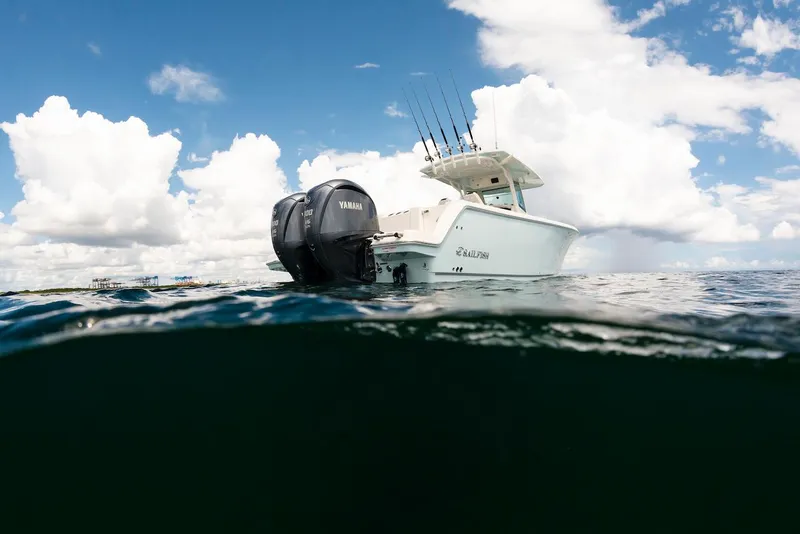 Slide: The Image of 2024 Sailfish 312 CC boat on water, Yamaha engine, under cloudy sky. - 17