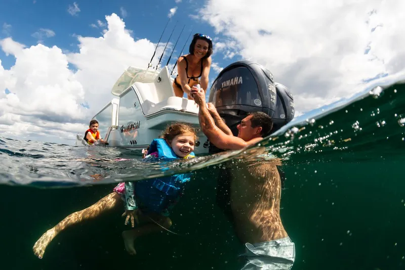 Slide: The Image of Family enjoying water activities near 2024 Sailfish 312 CC boat. - 20