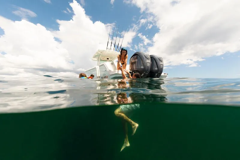 Slide: The Image of 2024 Sailfish 312 CC boat on water, people enjoying a sunny day. - 21