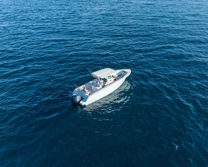 Slide: The Image of 2024 Sailfish 312 CC boat cruising on open blue water. - 33