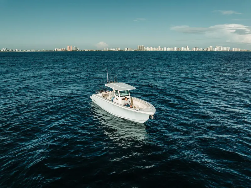 Slide: The Image of 2024 Sailfish 312 CC boat on open sea with city skyline in background. - 35