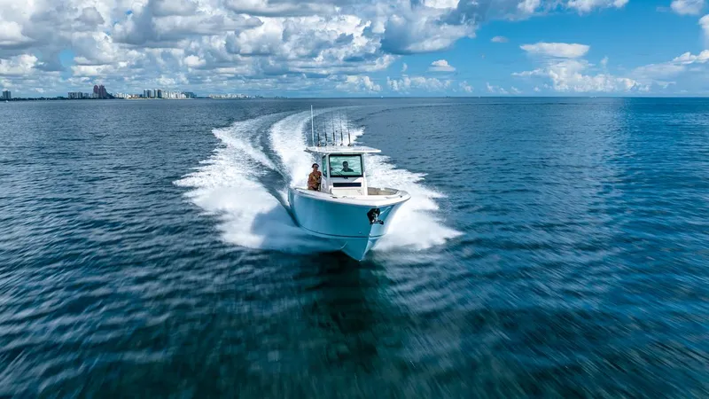 Slide: The Image of 2024 Sailfish 312 CC boat cruising on open ocean under blue sky. - 38