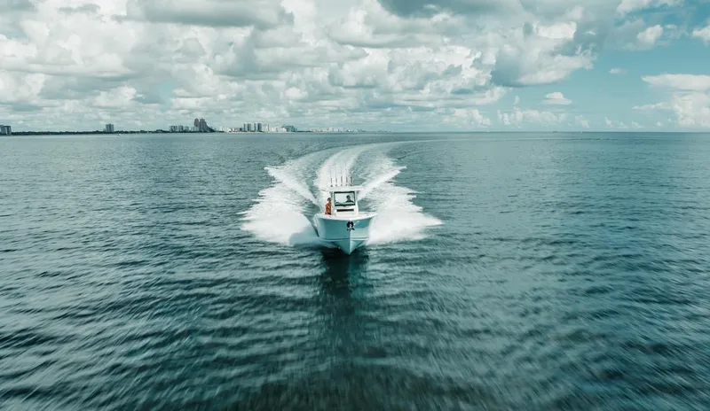 Slide: The Image of 2024 Sailfish 312 CC boat cruising on open ocean under cloudy sky. - 39