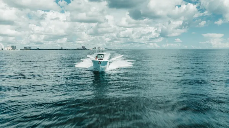 Slide: The Image of 2024 Sailfish 312 CC boat cruising on open ocean under cloudy sky. - 40