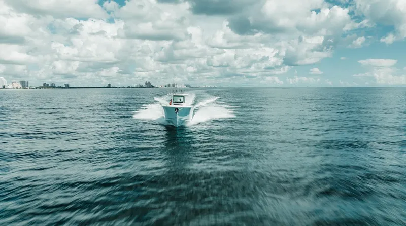 Slide: The Image of 2024 Sailfish 312 CC boat cruising on open ocean under cloudy sky. - 41