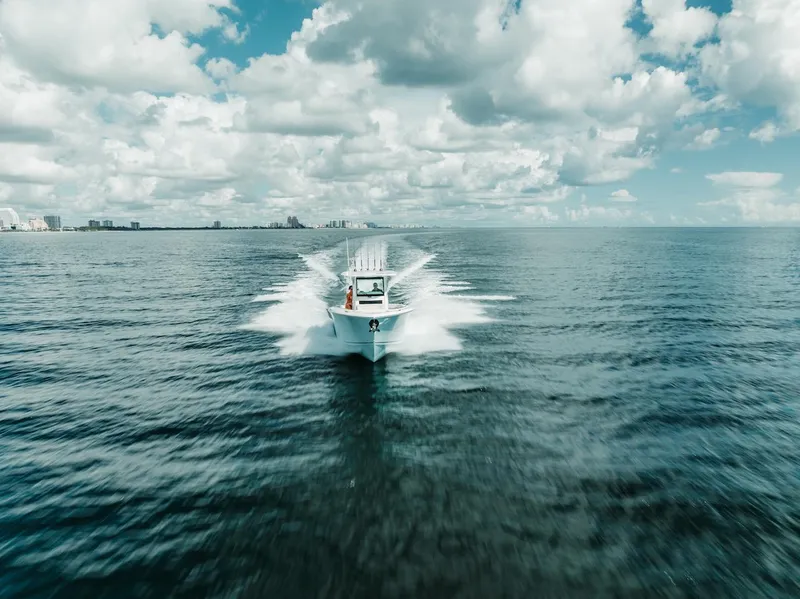 Slide: The Image of 2024 Sailfish 312 CC boat cruising on open ocean under cloudy sky. - 43