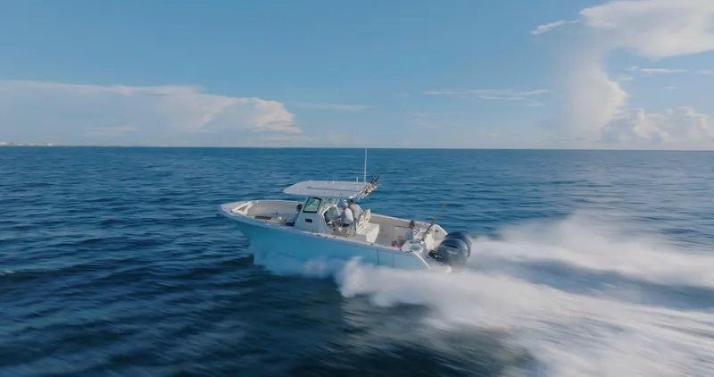 Slide: The Image of 2024 Sailfish 312 CC boat speeding on open ocean under clear blue sky. - 46