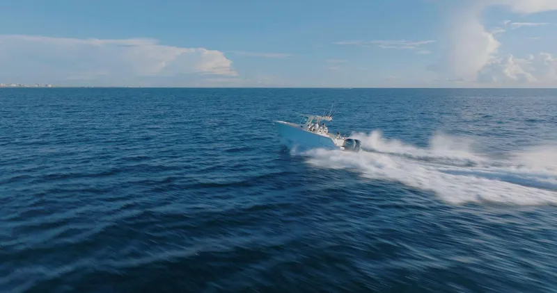 Slide: The Image of 2024 Sailfish 312 CC speeding across open ocean under clear blue sky. - 49