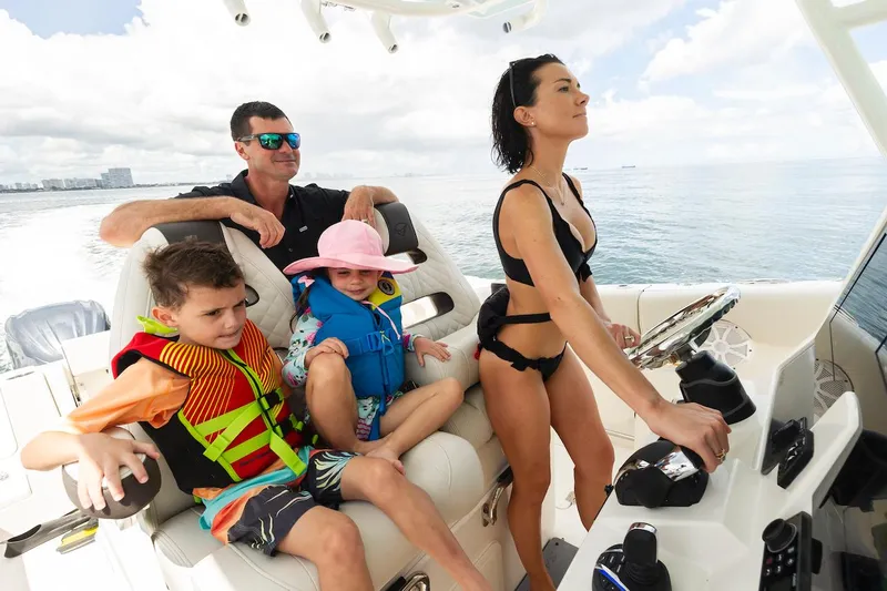 Slide: The Image of Family enjoying a ride on a 2024 Sailfish 312 CC boat. - 6