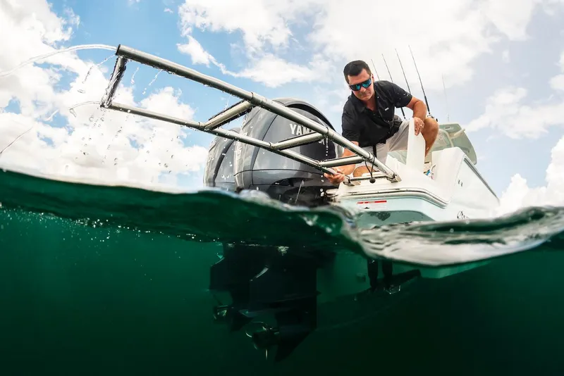 Slide: The Image of 2024 Sailfish 312 CC boat with Yamaha engine, man fishing, half-submerged view. - 9
