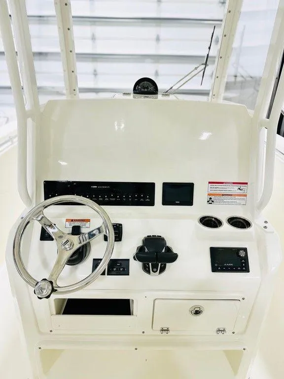 Slide: The Image of 2024 Cobia 280 CC boat console with steering wheel and controls. - 1
