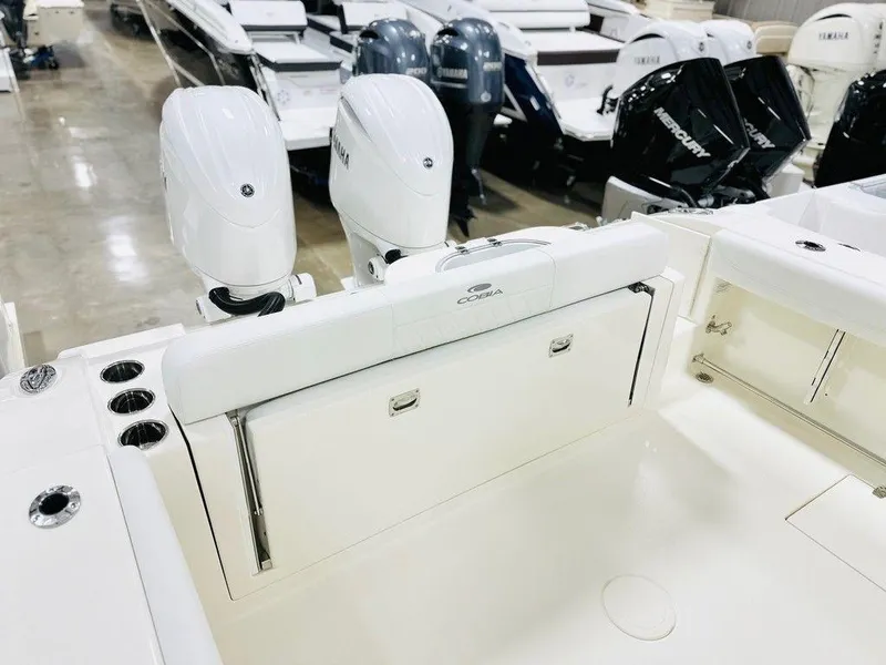 Slide: The Image of 2024 Cobia 280 CC boat with dual outboard engines in showroom. - 10