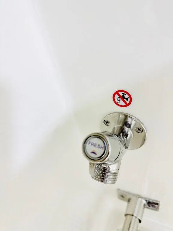 Slide: The Image of Close-up of a 2024 Cobia 280 CC fresh water valve with no smoking sign. - 13