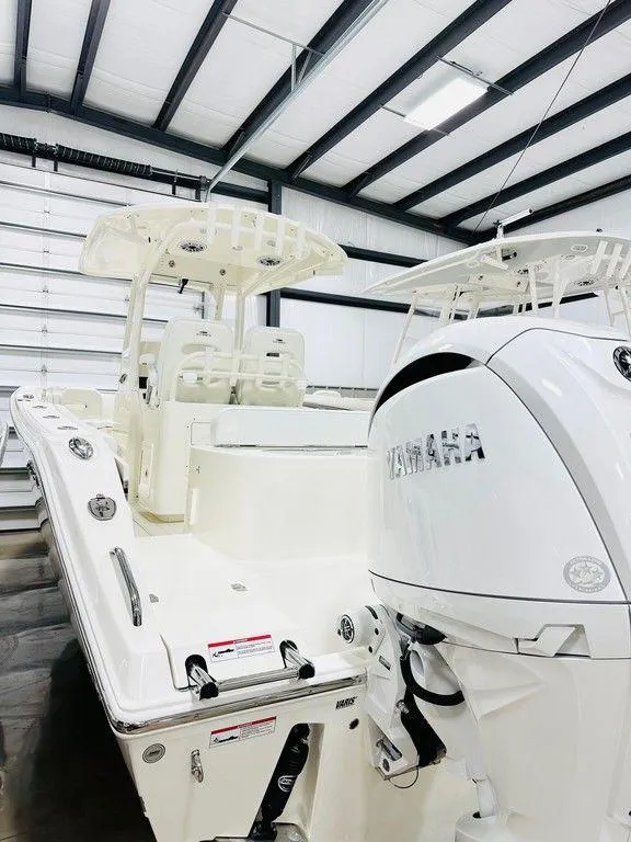Slide: The Image of 2024 Cobia 280 CC boat with Yamaha engine in a storage facility. - 16