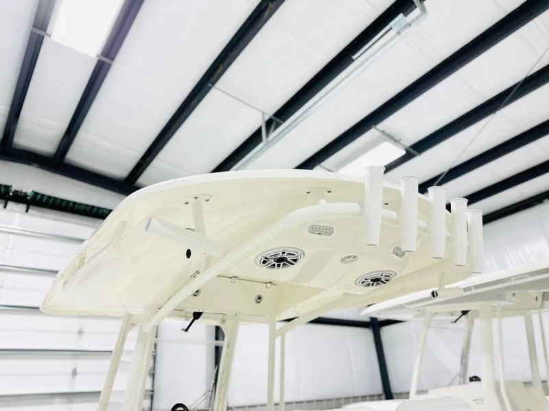 Slide: The Image of 2024 Cobia 280 CC boat top view in a modern indoor facility. - 4