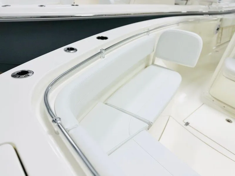 Slide: The Image of 2024 Cobia 280 CC boat interior with white seating and stainless steel railings. - 6