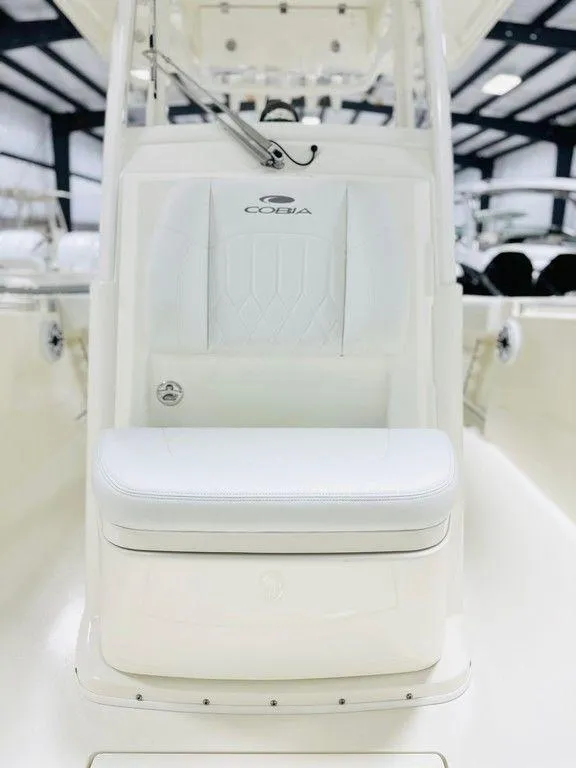 Slide: The Image of 2024 Cobia 280 CC boat interior with white seating and console. - 8