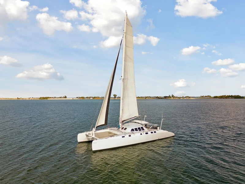 Slide: The Image of Sailing catamaran Technologie Marine Entincelle 60, 1999 model, on calm waters under blue sky. - 10