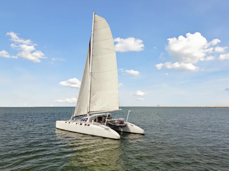 Slide: The Image of Sailing catamaran Technologie Marine Entincelle 60, 1999, on open water under a clear sky. - 11