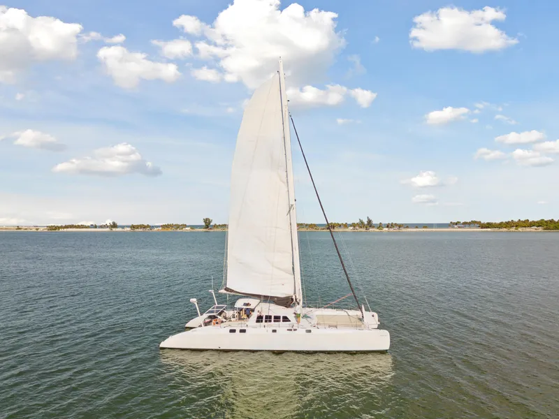 Slide: The Image of Sailing catamaran Technologie Marine Entincelle 60, 1999 model, on calm waters under a blue sky. - 12