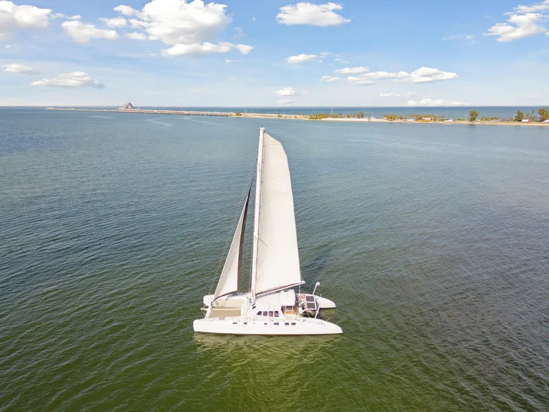 Slide: The Image of Sailing catamaran Technologie Marine Entincelle 60, 1999, on calm waters under a blue sky. - 13