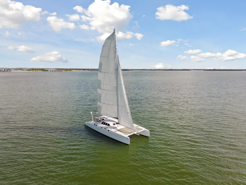 Slide: The Image of Sailing catamaran Technologie Marine Entincelle 60, 1999, on calm waters under a blue sky. - 14