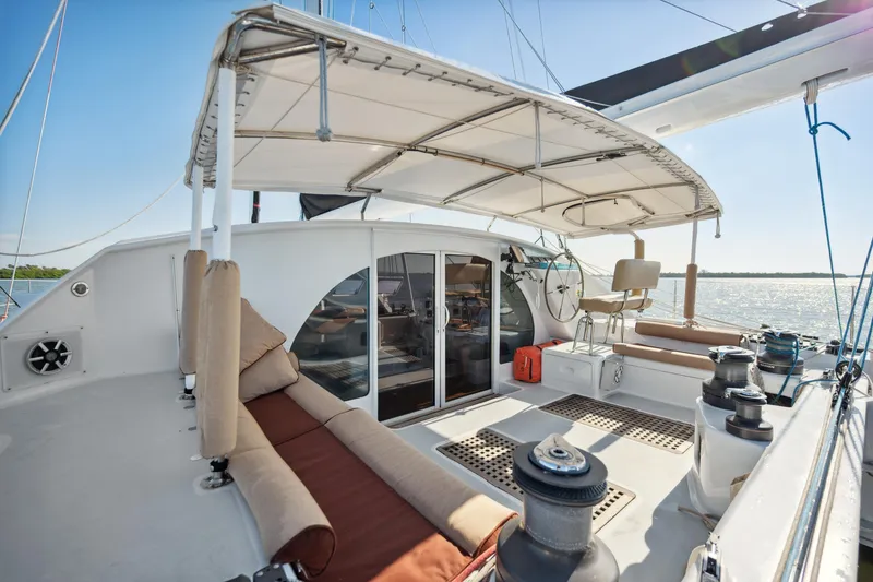 Slide: The Image of 1999 Technologie Marine Entincelle 60 yacht deck with seating and canopy, overlooking the water. - 24