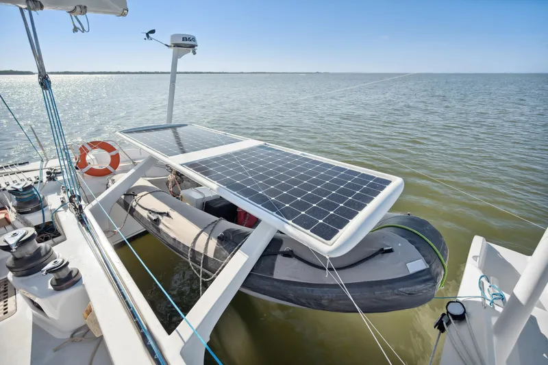 Slide: The Image of Technologie Marine Entincelle 60 yacht with solar panels and dinghy, 1999 model, on calm water. - 32