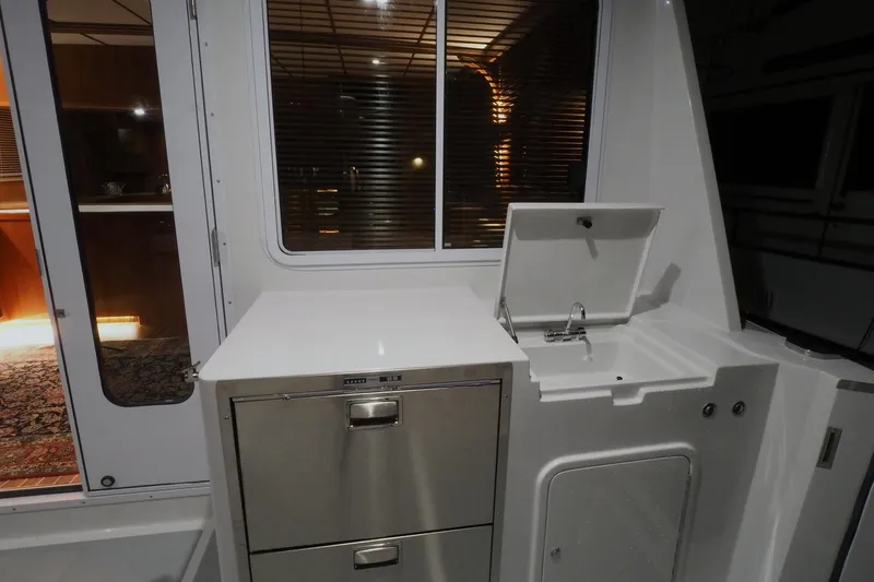 Slide: The Image of 2026 Helmsman Trawlers 46 Pilothouse interior with stainless steel drawers and sink. - 18
