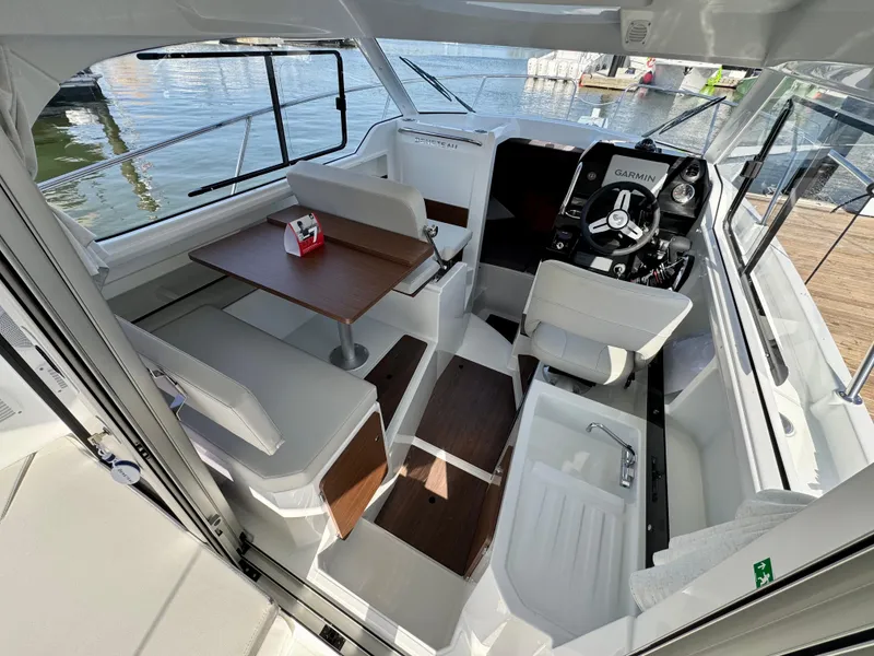 Slide: The Image of Interior of 2025 Beneteau Antares 8 boat, featuring seating, table, and helm station. - 5