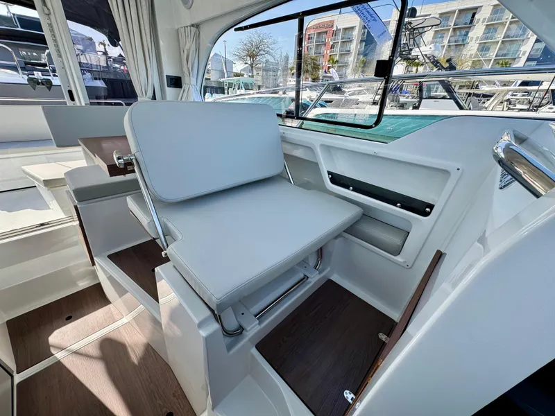Slide: The Image of 2025 Beneteau Antares 8 interior with modern seating and window view. - 9