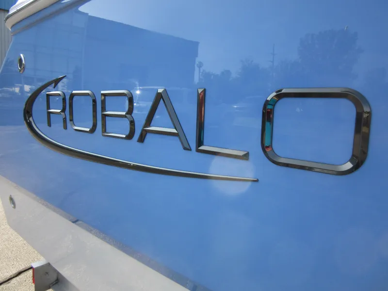 Slide: The Image of 2023 Robalo R230 Center Console boat logo on blue hull. - 3