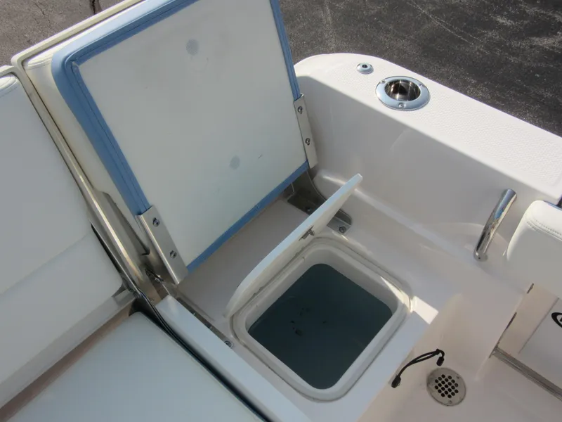 Slide: The Image of 2023 Robalo R230 Center Console boat with open storage compartment and cup holder. - 34