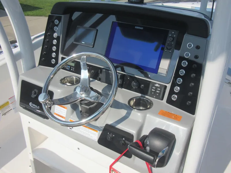 Slide: The Image of 2023 Robalo R230 Center Console dashboard with steering wheel and navigation display. - 35
