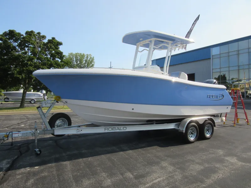 Slide: The Image of 2023 Robalo R230 Center Console boat on trailer, blue and white design. - 5