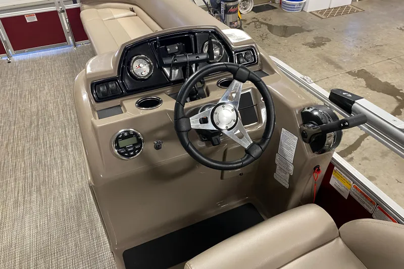 Slide: The Image of 2022 Ranger 200C boat dashboard with steering wheel and controls in a showroom. - 10