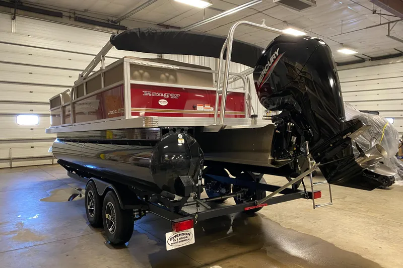 Slide: The Image of 2022 Ranger 200C pontoon boat with Mercury outboard motor in a garage setting. - 2