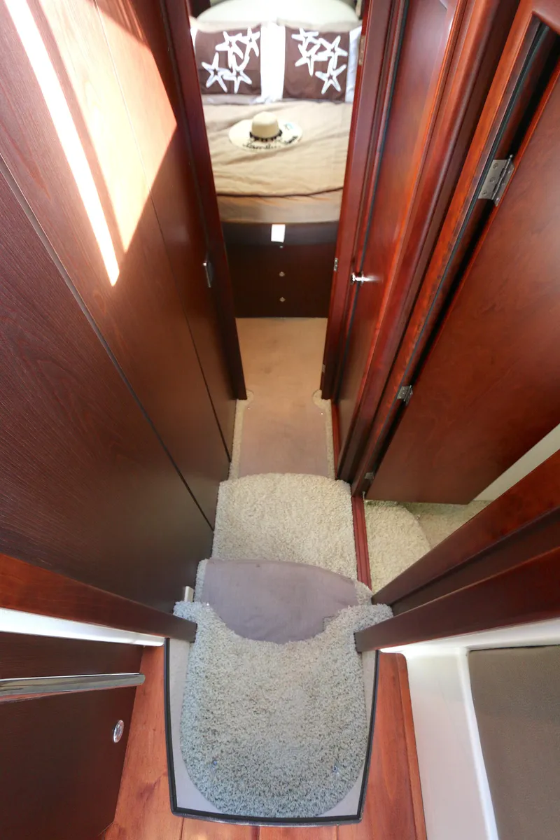 Slide: The Image of Interior hallway of 2013 Meridian 441 Sedan yacht with carpeted steps and wooden paneling. - 4