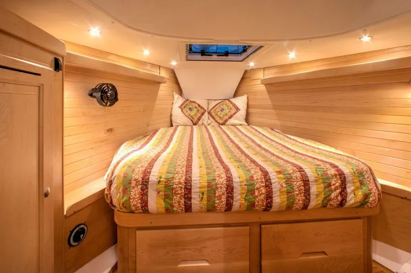 Slide: The Image of Cozy cabin interior of 2025 Tartan 395 yacht with colorful bedding and wood paneling. - 7