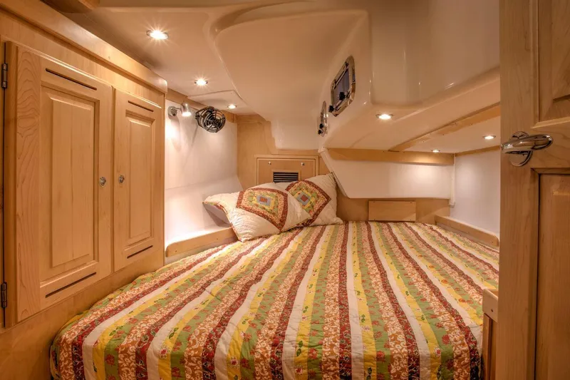 Slide: The Image of Cozy cabin interior of 2025 Tartan 395 yacht with striped bedding and wooden cabinetry. - 3