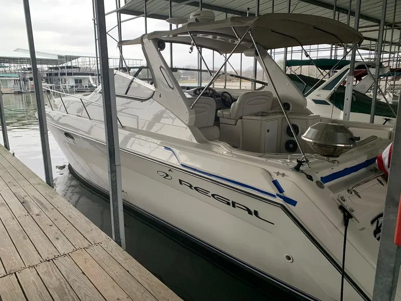 Slide: The Image of 1999 Regal 402 yacht docked in marina, featuring sleek white design and spacious interior. - 11