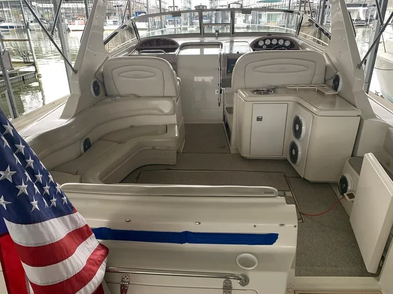 Slide: The Image of 1999 Regal 402 boat interior with seating, American flag, and control panel. - 13